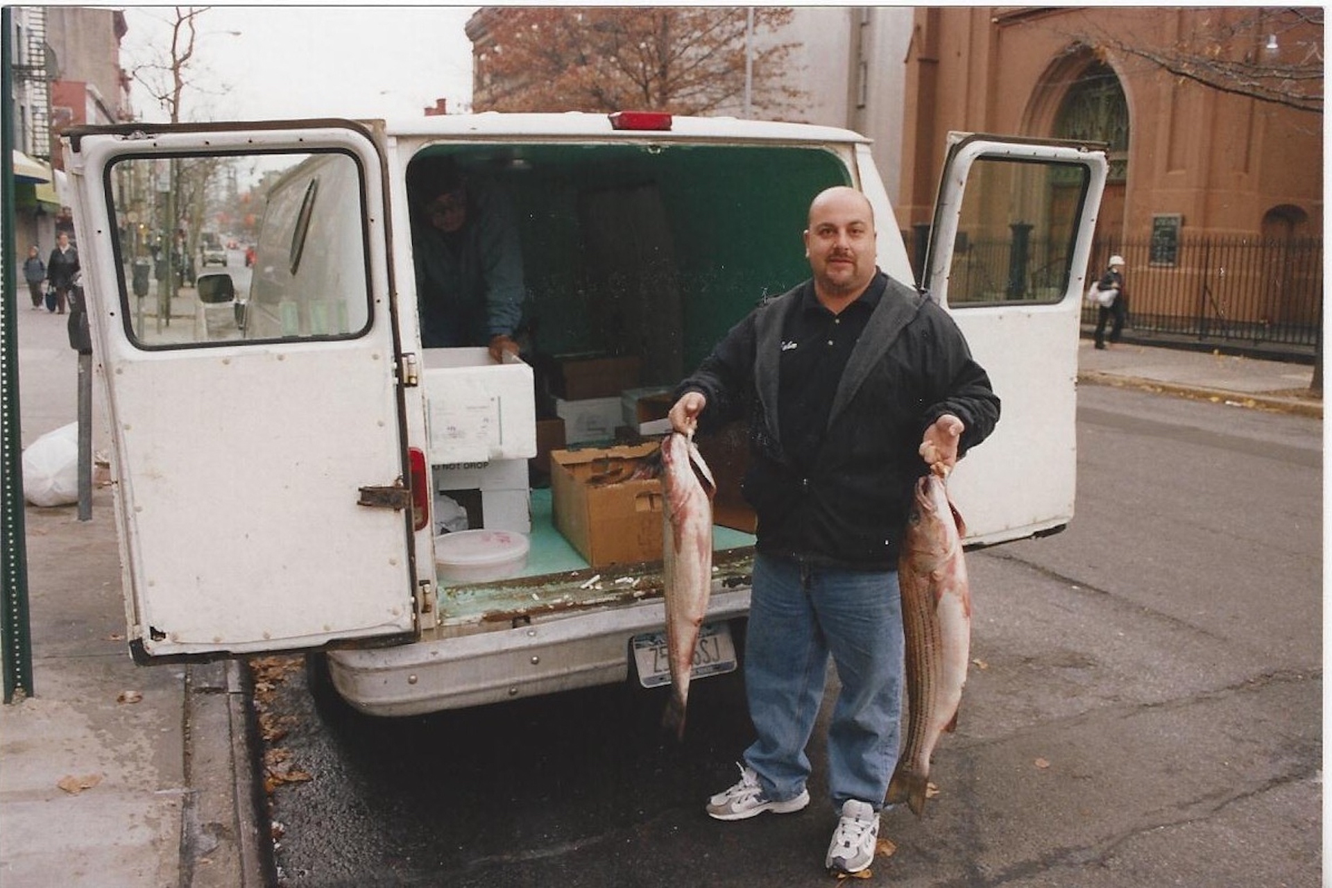 John, owner of Fish Tales Gourmet Seafood Market holding up fresh catch